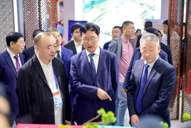 杜牧品牌首席运营官于哲(左)向山西省政协副主席王立伟、中国酒业协会理事长宋书玉(右)汇报品牌发展情况