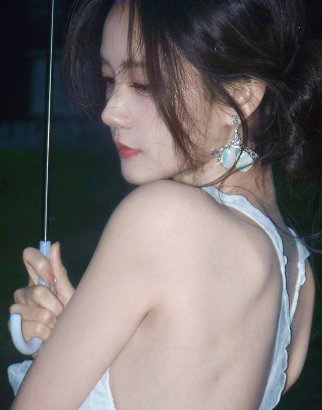 李一桐穿白色吊带裙身材窈窕 雨中撑伞氛围感十足