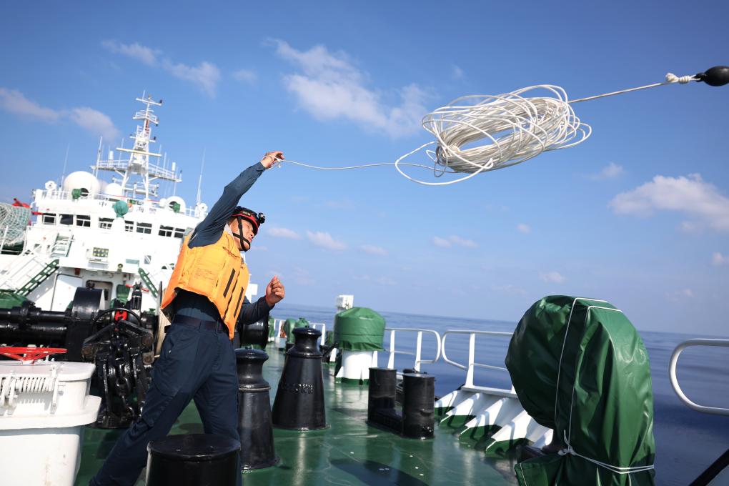 5月19日,海警执法员王鑫在川山舰甲板上进行海上抛缆绳训练。新华社记者 陈斌 摄