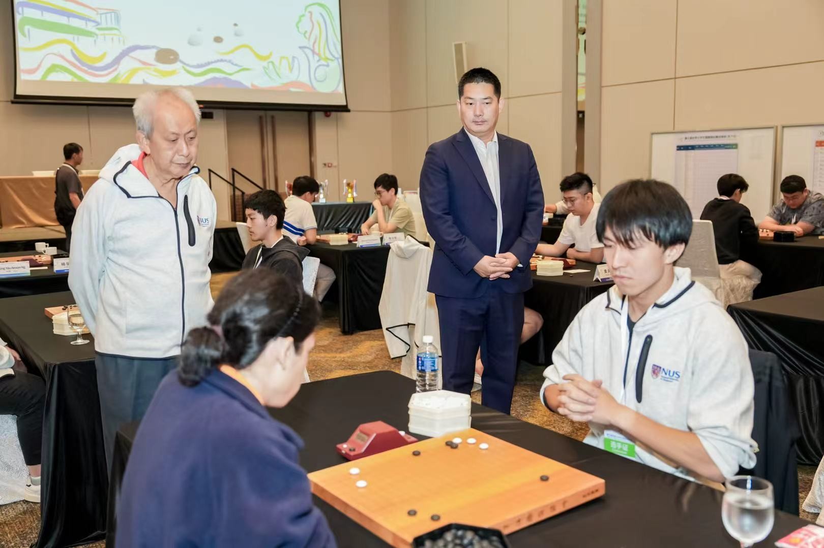 中国围棋协会主席常昊(右二)、新加坡围棋协会会长陈丁川(左一)观战。中国围棋协会供图